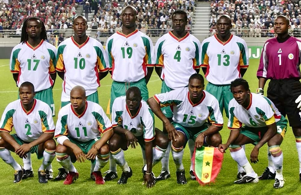 In 2002 World Cup opening game Senegal sensationally beat France 1-0. Standing: Coly, Fadiga, Bouba Diop, Malick Diop, Diatta, Sylva. Squatting: Daf, Diouf, N'Diaye, Diao, Cisse, Manager: B. Metsu. The Lions of Teranga reached quarter-final on that edition.